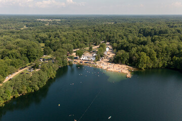Fototapeta premium Aerial view of people enjoying a sunny lake beach