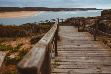 Obraz premium Wooden walkway leading down to a coastal beach