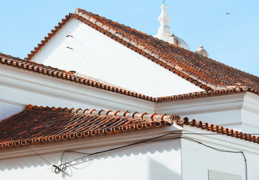 Terracotta tile roof on whitewashed building exterior