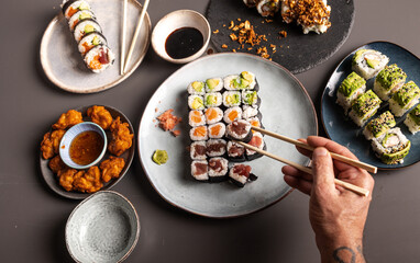 Hand picking fresh tuna maki from a sushi platter © Cavan