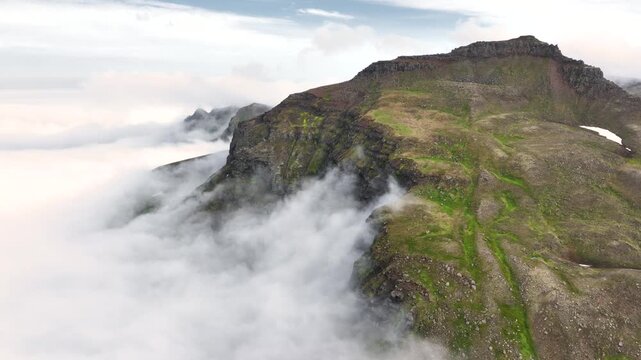 Aerial view of a rugged mountain landscape with a cloud inversion in the east of Iceland