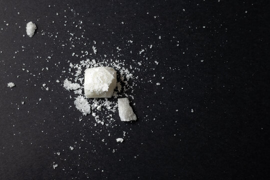 Broken sugar cube on black background