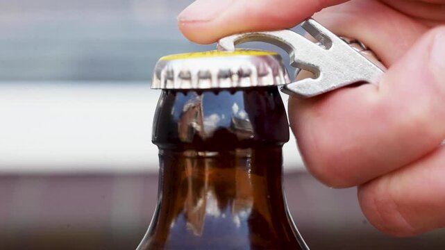 Video using a bottle opener to open a beer.