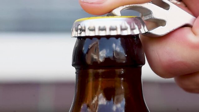 Video trying to open a beer bottle with an opener.