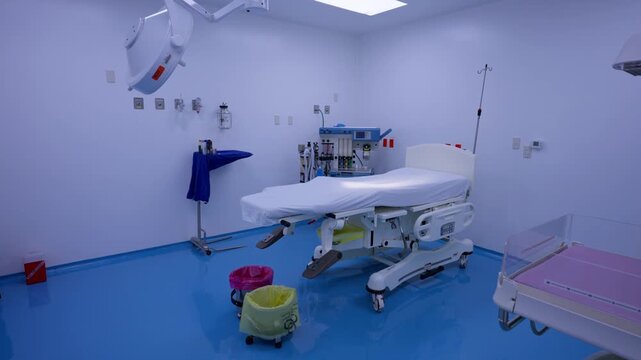 Empty hospital procedure room with patient bed, medical equipment and glossy blue flooring, empty nobody interior without people