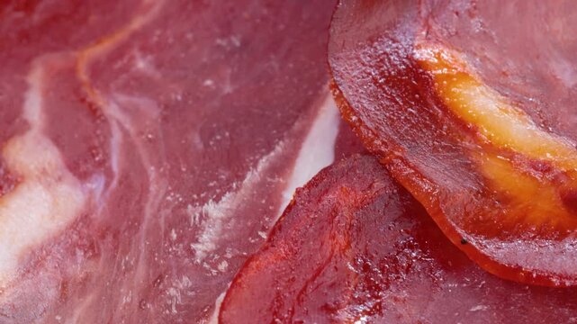 Macro view of sliced basturma meat rotating slowly on wooden surface.