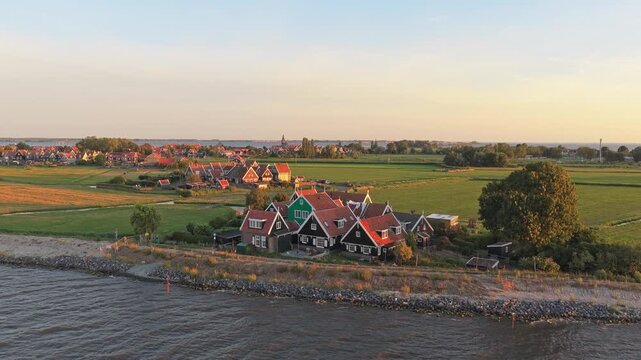 Aerial shot slowly rising over the traditional dutch fishing village of marken, revealing the beautiful houses and surrounding green landscape