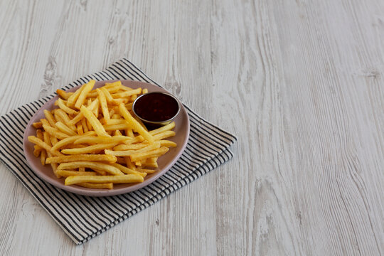 Homemade French Fries with Sweet and Sour Sauce, side view.