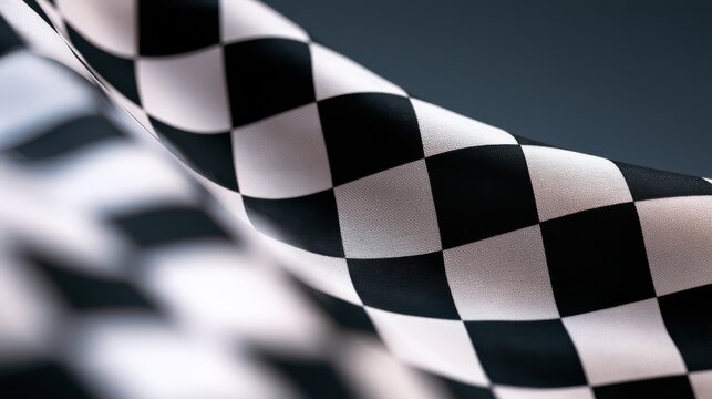 A close-up image of a black and white checkered flag, symbolizing racing and speed, with a smooth, waving texture.