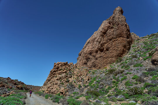 Lone hiker below towering crag, Tenerife