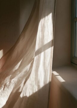 Window with a beige curtain hanging on the right side. the curtain is made of a light-colored fabric and is draped in a way that creates a drape-like effect.