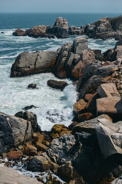 Ocean waves crashing on a rugged rocky shoreline