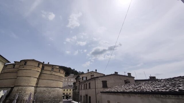 Inquadratura dal basso della celebre fortezza a forma di testuggine a Sassocorvaro, con i tetti del borgo medievale marchigiano sullo sfondo