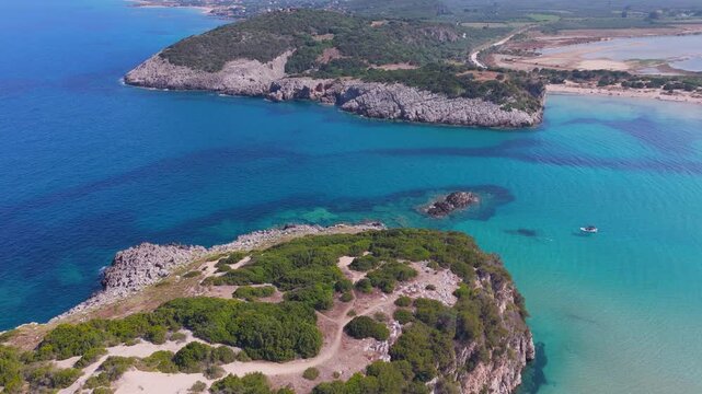 Low Aerial Flight over Rocky Cape and Crystal Clear Turquoise Sea at Voidokilia Beach, Peloponnese, Greece