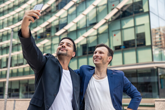 Tech startup founders celebrating success taking selfie outdoors