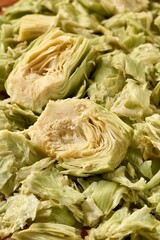 Obraz premium Organic Artichoke Hearts And Sliced Petal Pieces Freshly Harvested Vegetable Texture Background.