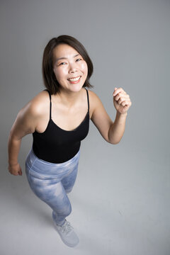 A woman in her 40s enjoying fitness exercises with a smile and energy; running and walking workouts focused on health and weight loss during menopause; looking at the camera, overhead shot