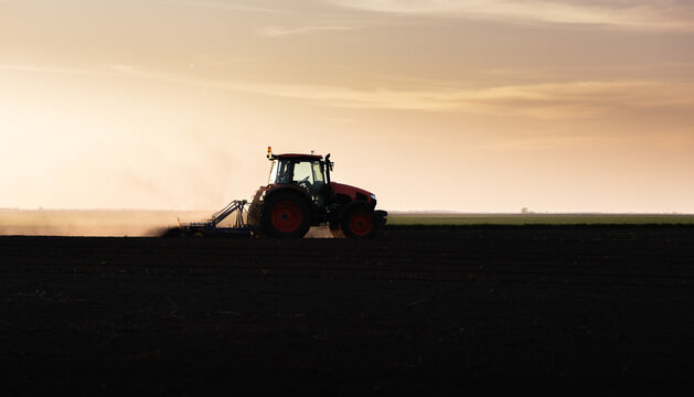 Farmer in tractor preparing land for sowing