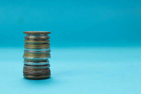 Flat Lay of High Stack Coins Over Blue Background