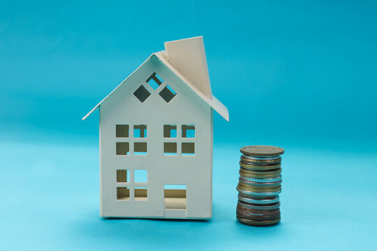 Closeup of Miniature Model with Metal Coins Pile Isolated on Blue Background