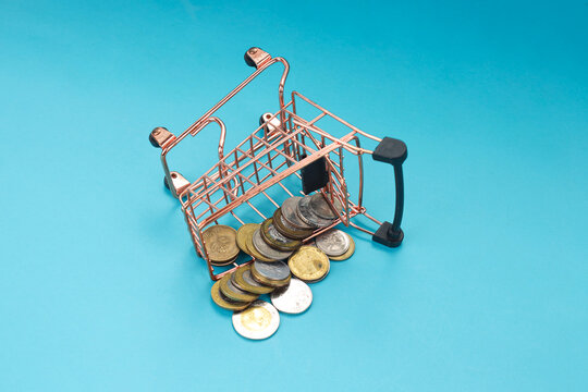 Closeup of Fallen Basket with Scattered Coins Against Blue Background