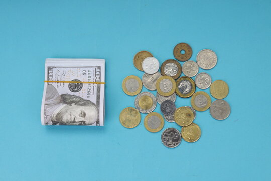 High Angle of Rubber Banded Dollars Beside Diverse Coins for Financial Savings