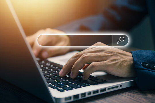 Business professional typing on laptop with digital search bar interface, representing online search, web browsing, information discovery, SEO research, and modern internet technology.