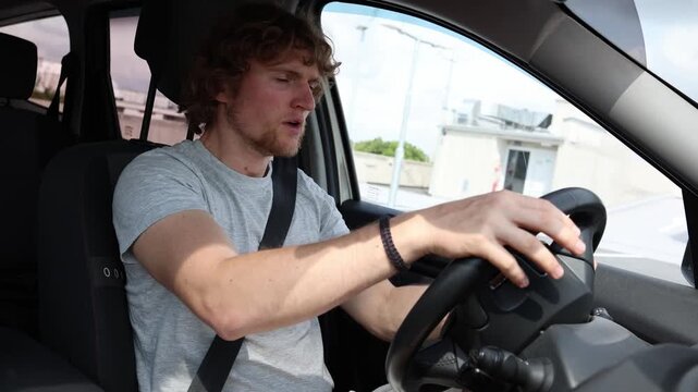 Young driver falls asleep behind the wheel and suddenly wakes up while the car is moving showing dangerous drowsy driving fatigue and serious crash risk on the road ahead
