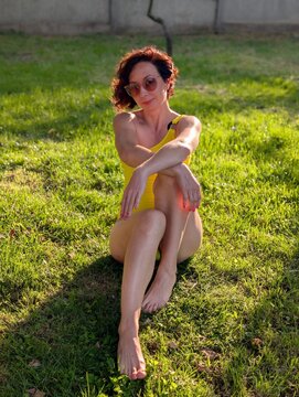 Woman Relaxing on Grass in Yellow Swimsuit