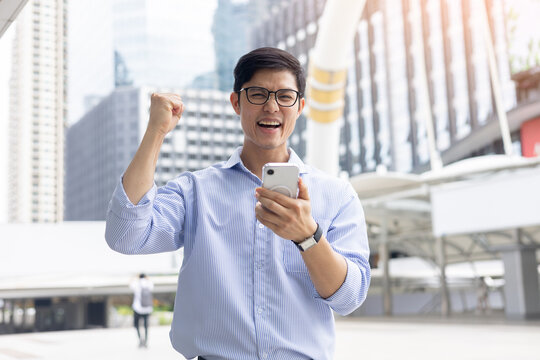 close up young  asian businessman raised hand with happiness feeling after complete and get a new job position in city for new career path concept