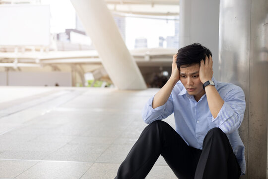 slow motion scene adult employee man sit on ground outside office with stress emotion after disappoint from job interview or unemployed for economic global and business concept
