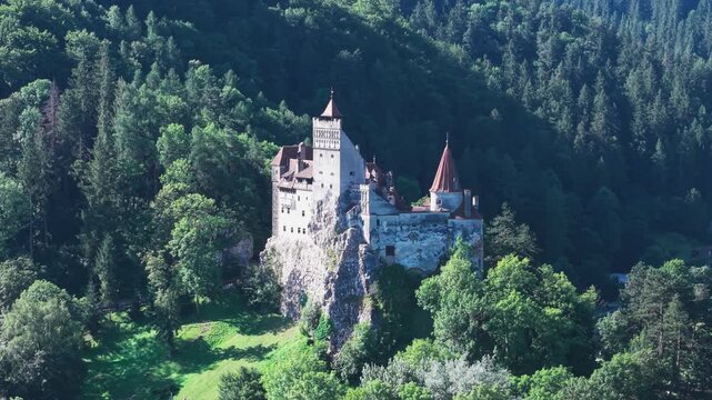 Bran Castle surrounded by forest and Carpathian Mountains in Transylvania, Romania ,drone footage