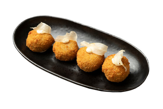 Golden fried croquettes on black plate with transparent background