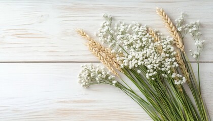 Naklejka premium Minimal Bouquet of Wheat Stalks and Babys Breath Flowers Arranged On Rustic White Wood Background