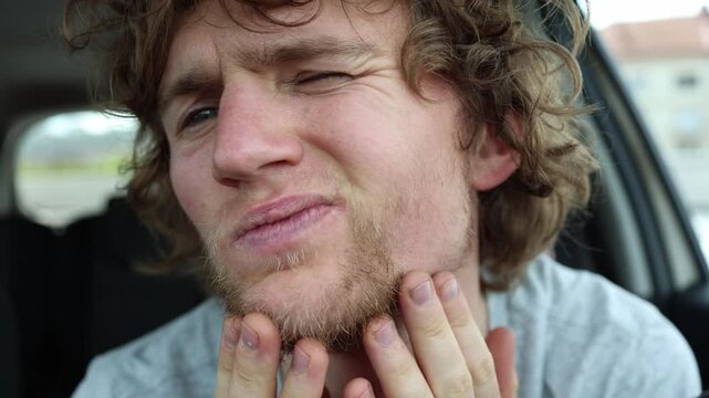 Patchy beard growth leaves thin facial hair and visible sparse areas on the chin as a man touches his face and examines why his beard grows with such uneven density naturally