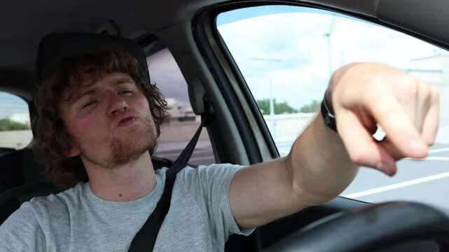 Overconfident young driver thinks he is skilled and cool as he casually steers a moving car with one finger showing risky careless behavior and poor road safety habits