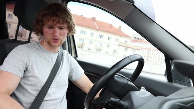Young driver cannot understand why the car will not start and grows a bit nervous while checking controls and facing an unexpected vehicle problem during his city commute
