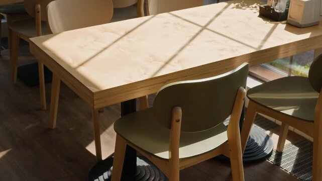 Empty wooden table and chairs standing in modern office coworking space. Footage perfect for remote work, hybrid business presentations, or hospitality industry marketing videos