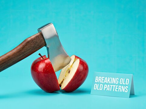 Axe splitting a red apple with a card reading breaking old patterns suitable for self help content symbolizing habit change and new beginnings