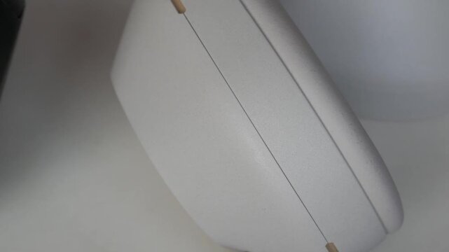 Headphones and white object move past each other on a plain, well-lit surface
