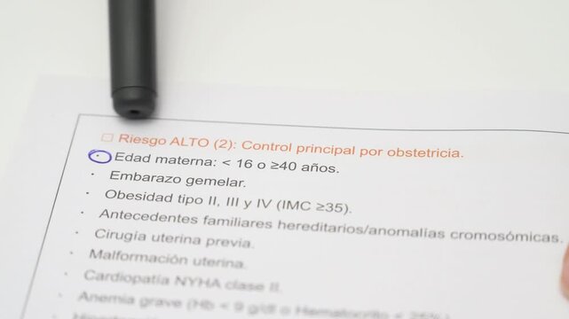 Close up of pen pointing at maternal age high risk factor on obstetrics report