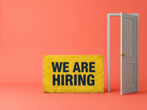 Yellow doormat reading WE ARE HIRING next to an open door suitable for recruitment content symbolizing career opportunities and growth