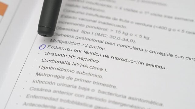 Close up of pen pointing at assisted reproduction pregnancy on medical document