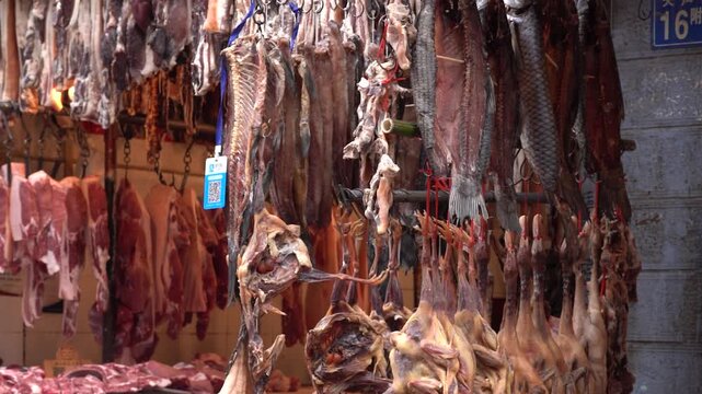 Traditional meat market stall with hanging cured fish, poultry and pork in China