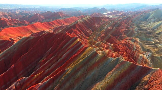 Aerial view of spectacular Zhangye Colorful Danxia landform, vibrant rainbow mountains under blue sky with white clouds, Gansu China
