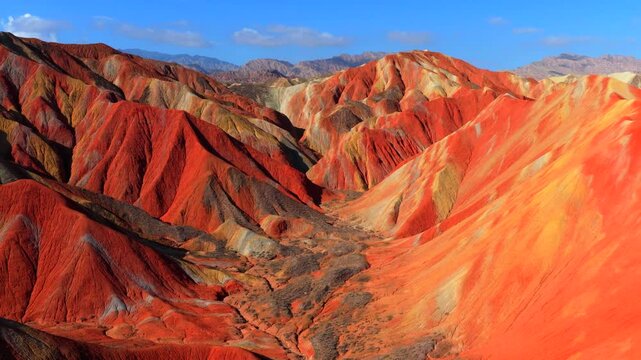 Aerial view of spectacular Zhangye Colorful Danxia landform, vibrant rainbow mountains under blue sky with white clouds, Gansu China