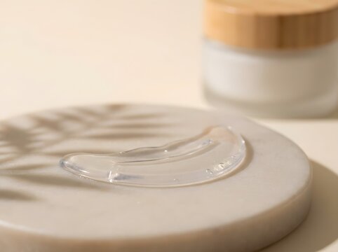 Clear gel eye patch on stone podium with cream jar for skincare beauty product mockup