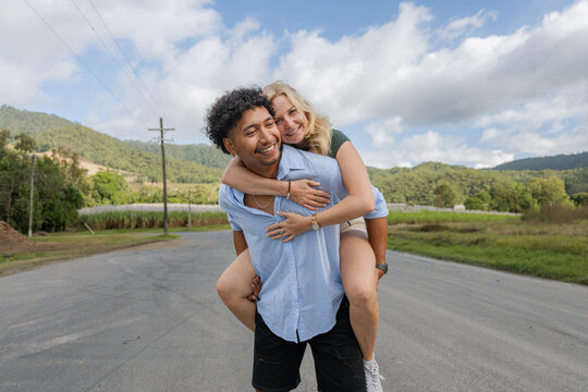 Young in love mixed race couple smiling during a piggyback ride