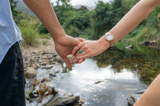 Interracial couple holding hands close-up on outdoor walk
