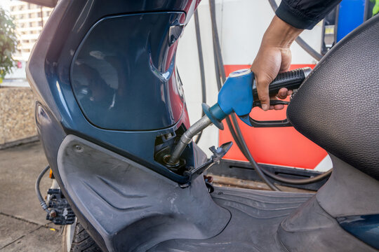 Close-up of man refuelling his scooter